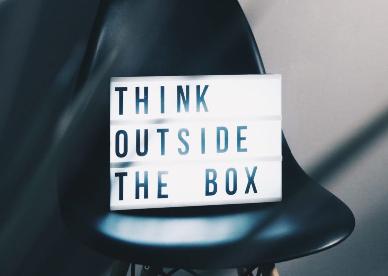 Lightbox with "think outside the box" written in it sitting on a chair
